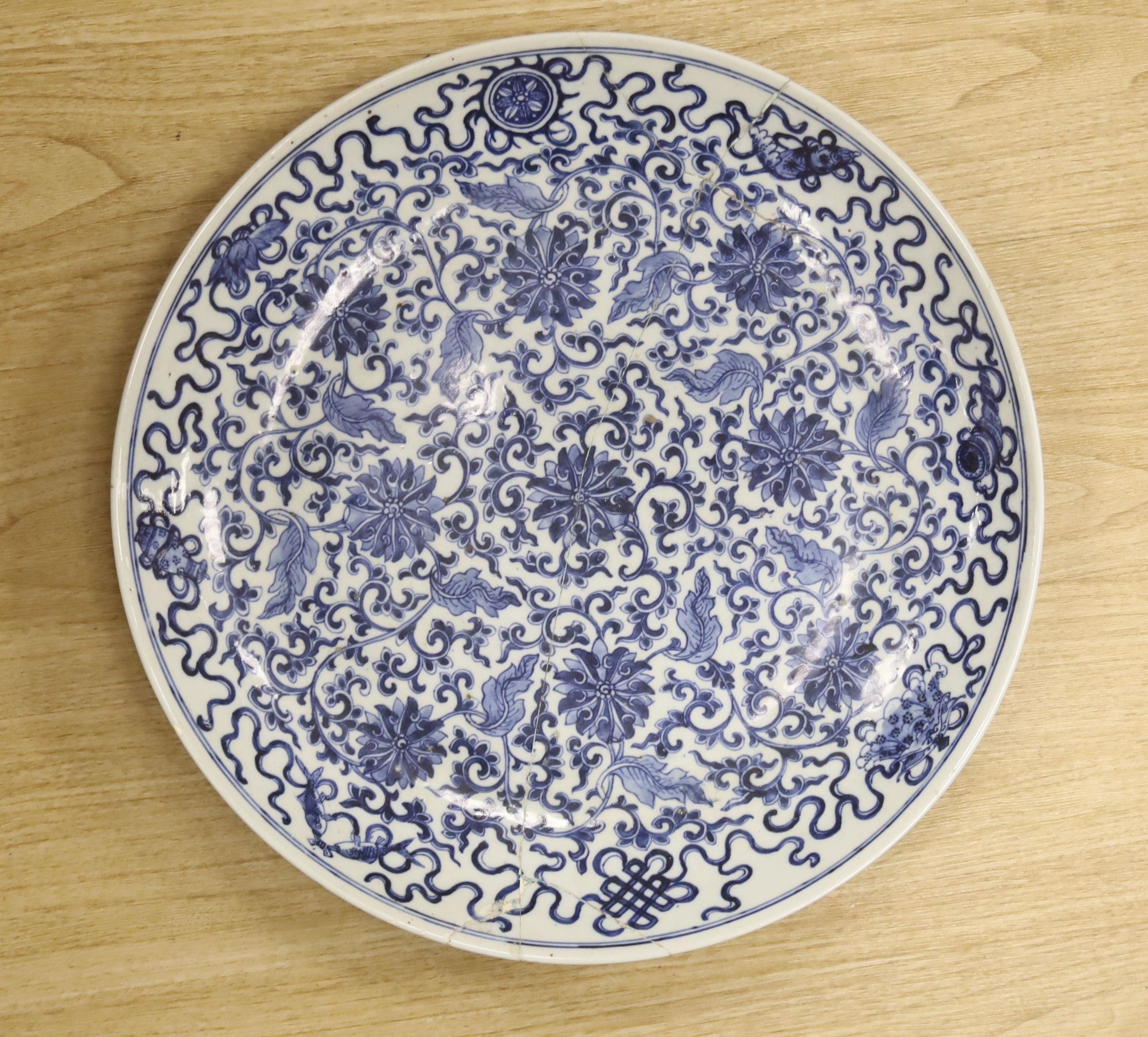 A large Chinese blue and white 'lotus and eight Buddhist emblems' dish, Daoguang period, repaired. 46cm